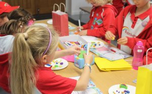 Impact report image: 5 Rainbows taking part in Super Rainbows activities, including clay moulding, and bead keyring making 